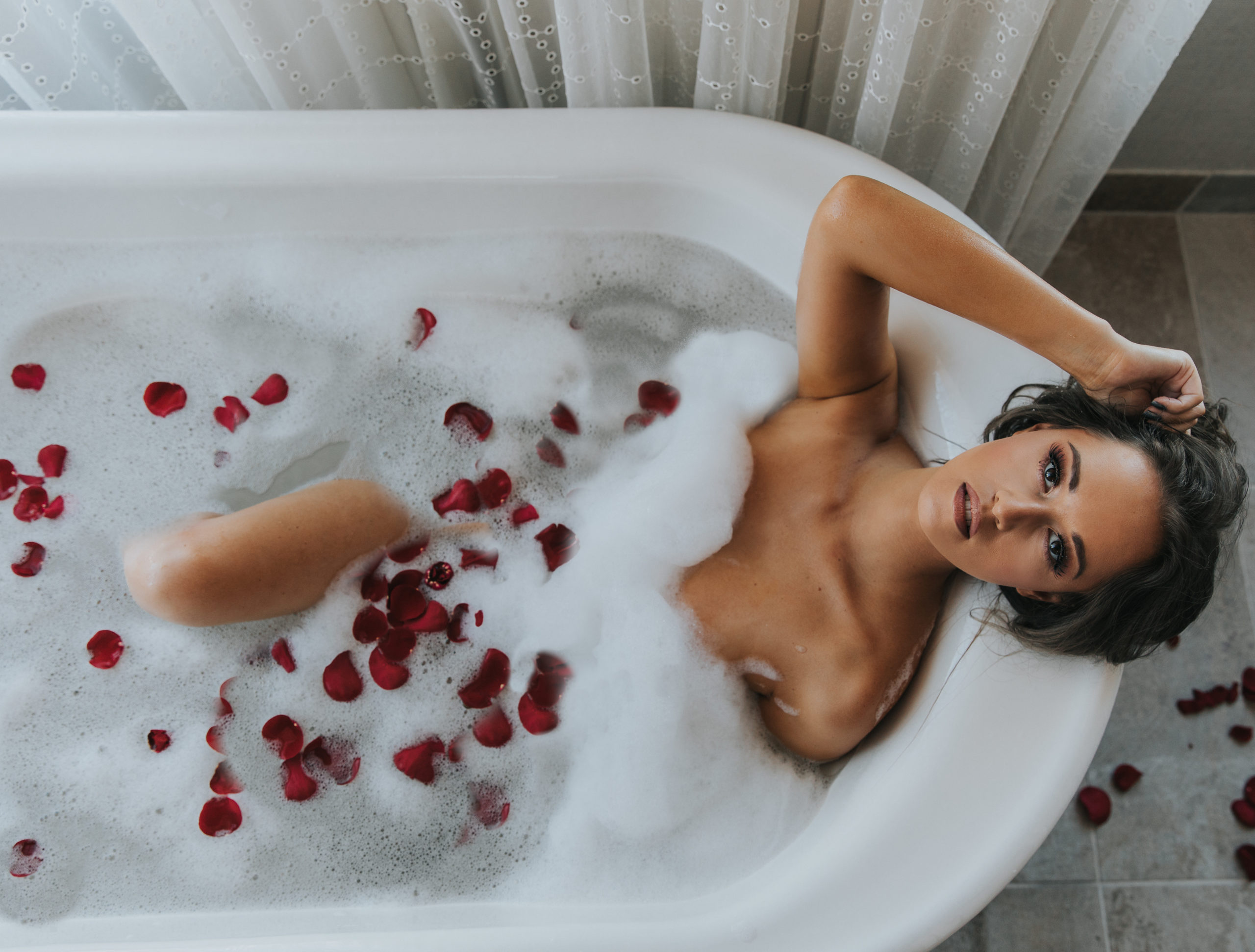 Woman in a bubble bath with rose petals