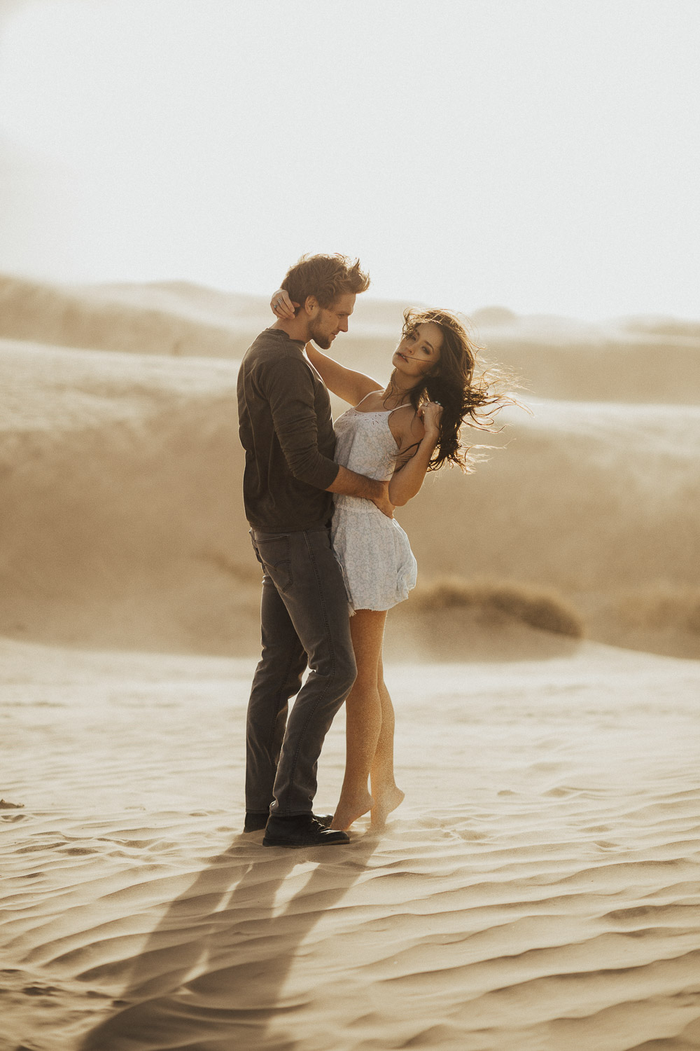 beautiful couple standing in a sand storm