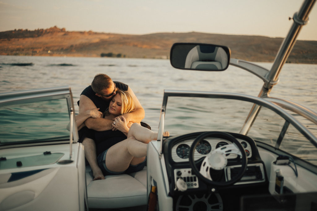 Couple is snuggled up in the front of a boat