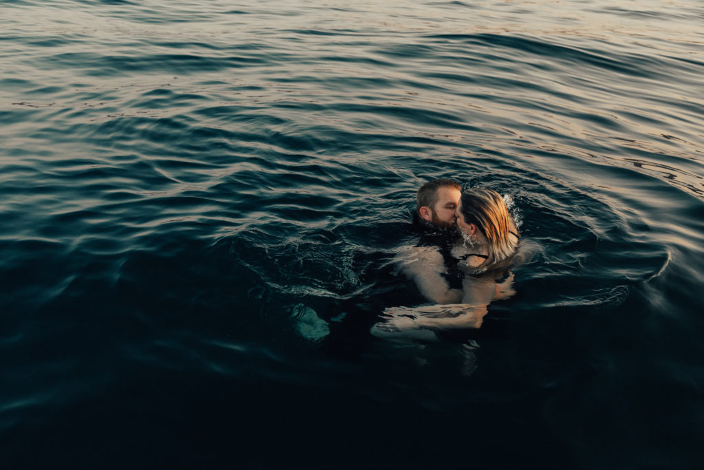 Couple kissing in the water during couples session. 