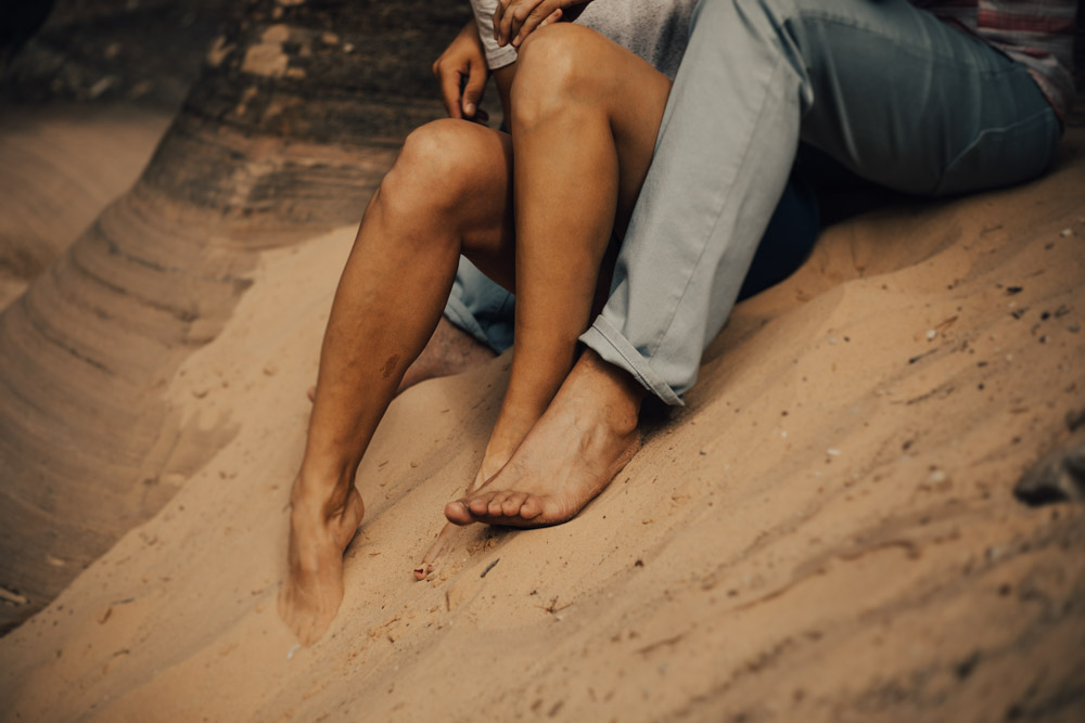 barefoot photo of couples feet in sand in Zion national park