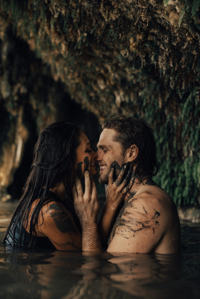 Couple kissing  and rubbing mud on each other during couples session 