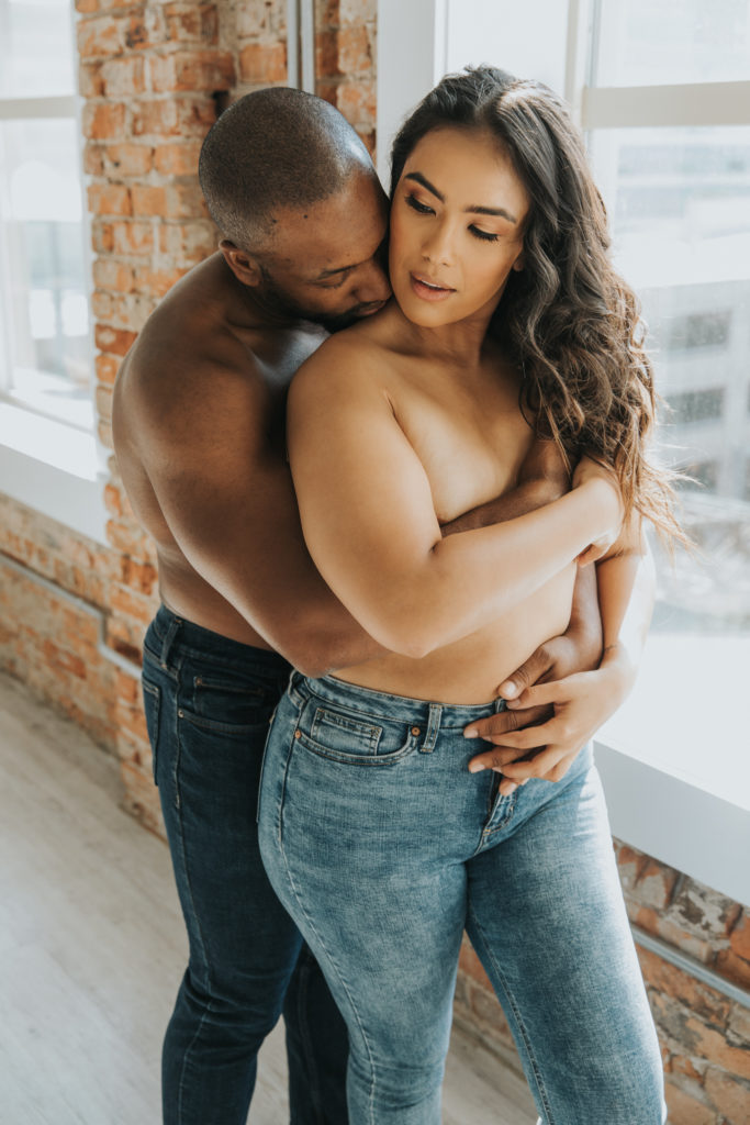 Beautiful couple hold each other during boudoir shoot 
