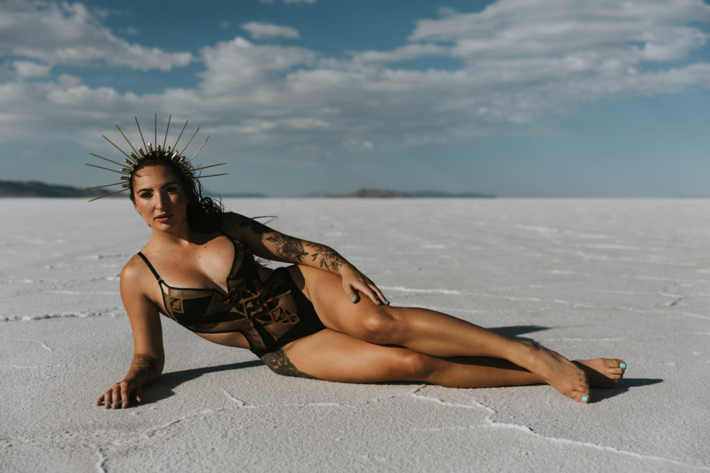 A woman wearing black lingerie and laying on the bonneville salt flats.